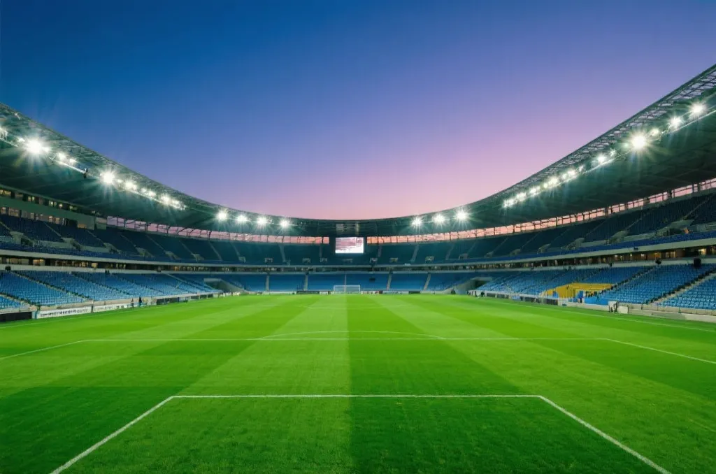 An expansive view of a magnificent modern soccer stadium at dusk with vibrant green turf and bright stadium lights